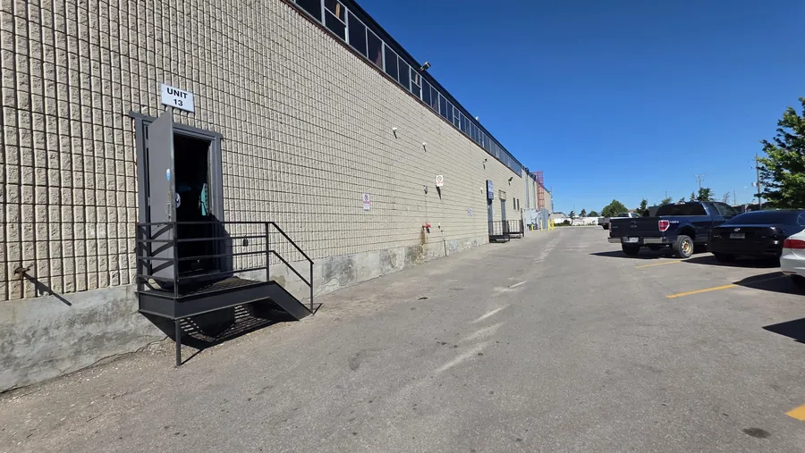 Concrete block wall with a repaired and parged foundation base running alongside a freshly striped parking area.