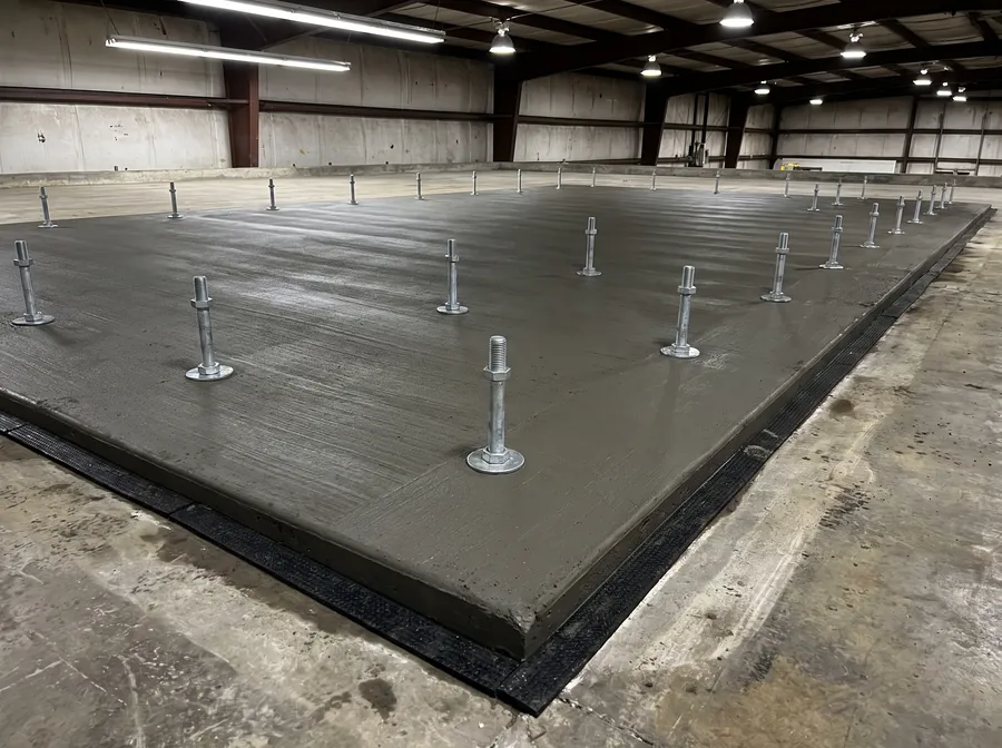Isolated reinforced machine pad with projecting anchor bolts and an isolation joint