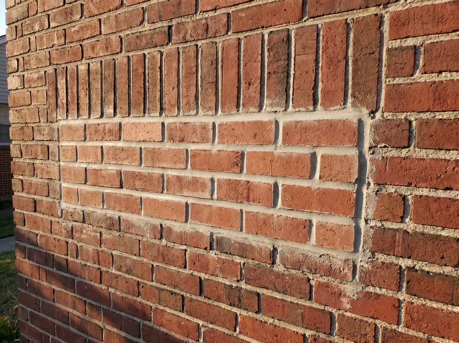 Replaced bricks and tuckpointed joints blending into the original bond pattern